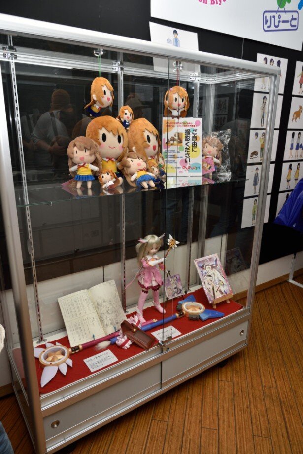 スペース中央の展示ケースには、ぬいぐるみやドールなどが陳列。上段のこまぐるみはプライズとして7月以降に展開される予定<br>