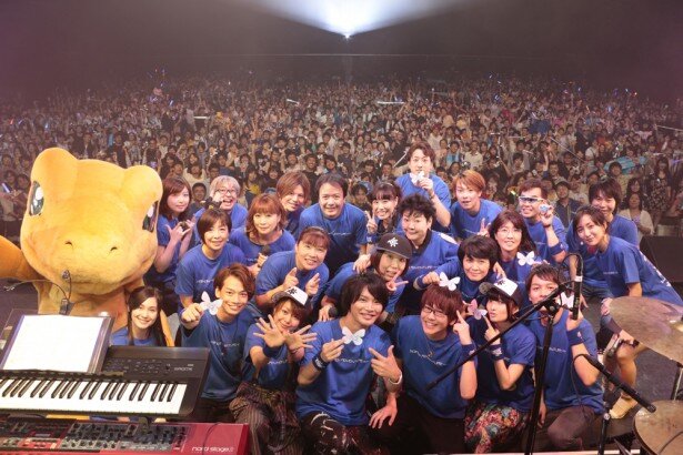出演者と観客の集合ショット。それぞれの手には主題歌である「Butterfly」の蝶を象ったペーパーが握られています<br>