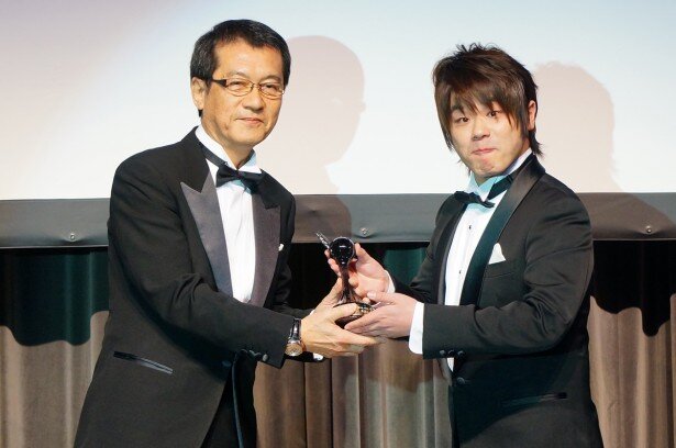 トロフィーを受け取る松岡禎丞さん<br>